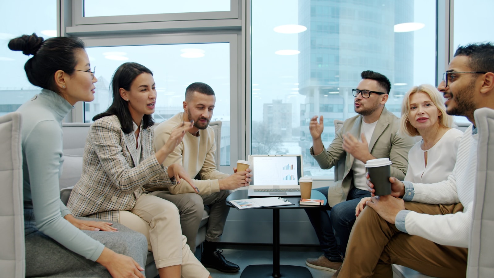People in a small professional group discussion around a low table.