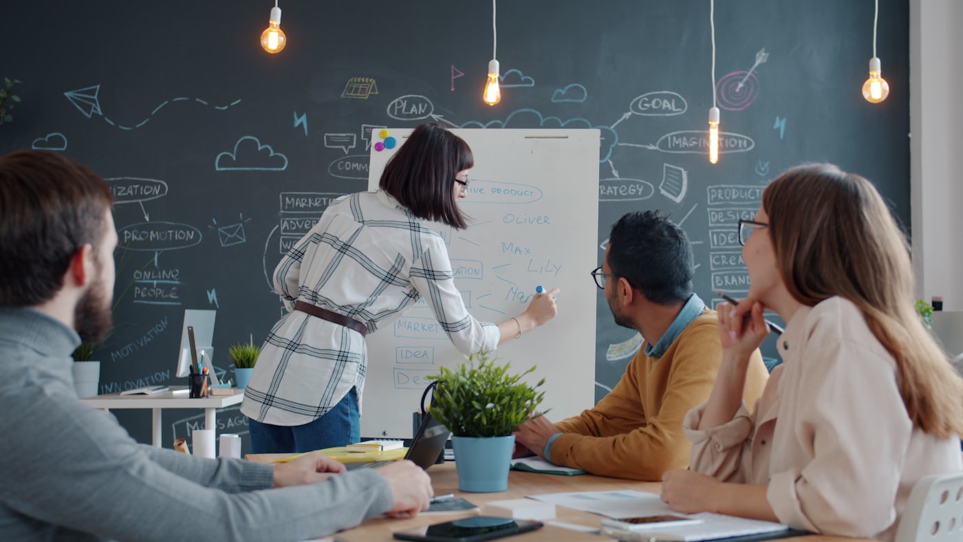 People gathered around a whiteboard during a planning discussion.